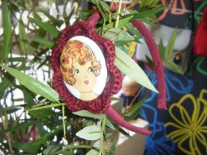 Diadema realizada con imagen plastificada de una mariquita , flor de lana hecha a mano en color Burdeos.. Forro de la diadema en color burdeos. Hecho a mano